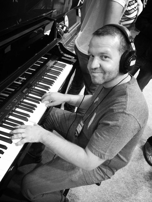 Clever Neves ao piano, com fones de ouvido
